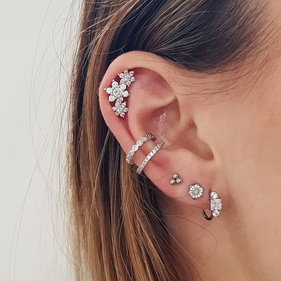 Chica mostrando sus múltiples pendientes en el oído derecho