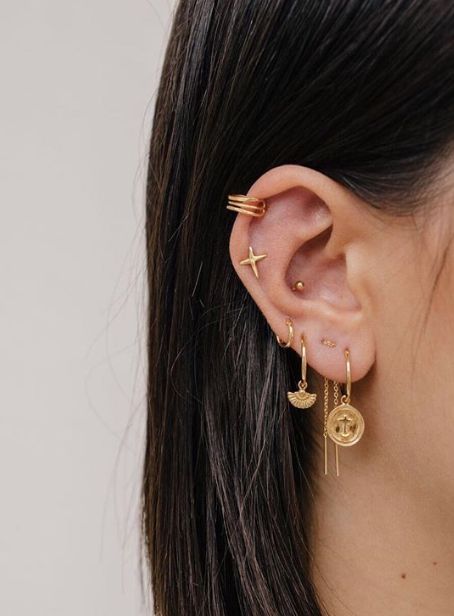 Chica mostrando sus pendientes dorados en el oído