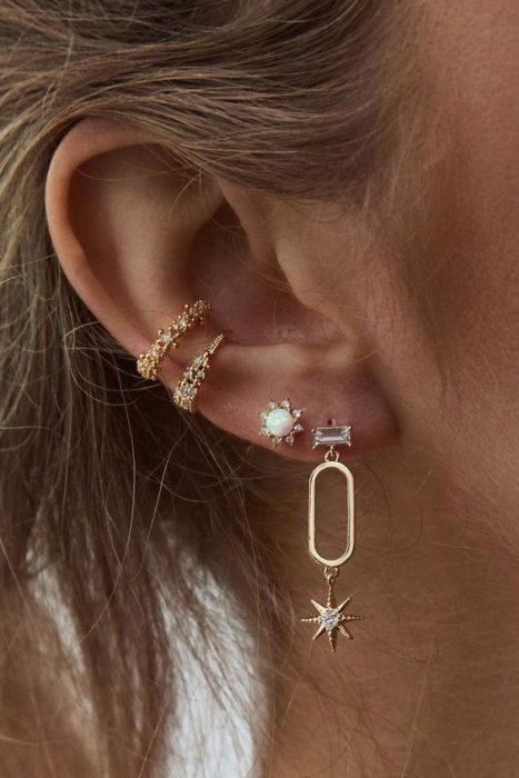 Chica mostrando sus pendientes largos en forma de rectángulo con estrellas
