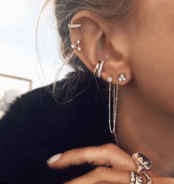 Chica con pendientes plateados en todo el oído