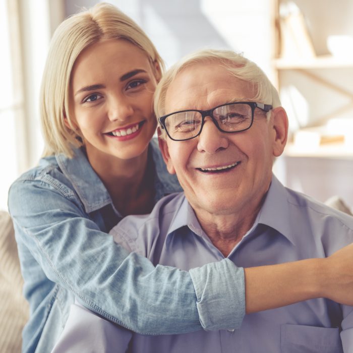 Abuelo y nieta abrazados, sonriendo