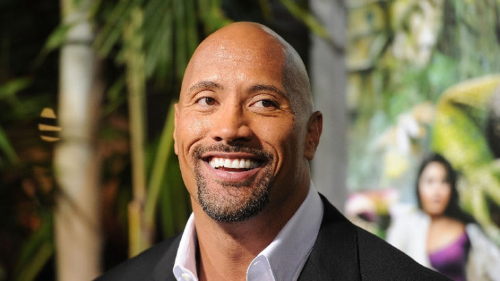 Dwayne Johnson sonriendo en la alfombra roja de Jumanji
