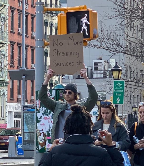 Chico levantando un cartel con una protesta en contra del servicio de streaming