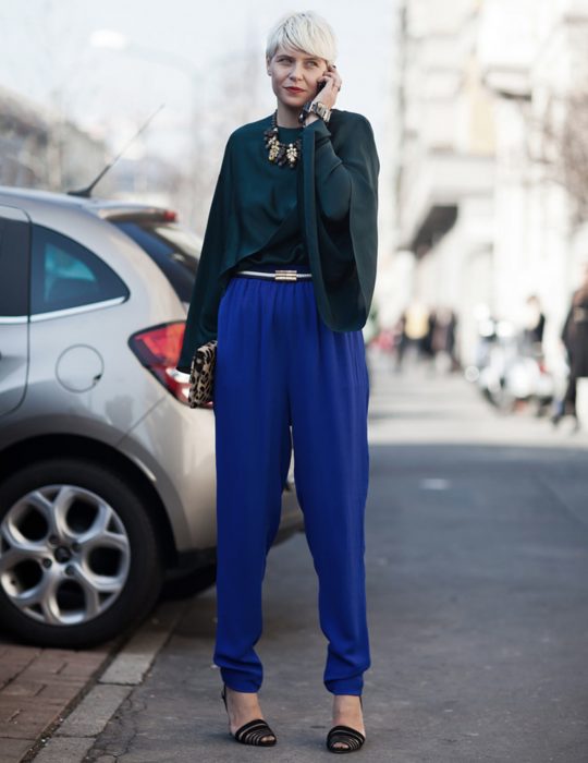 Pantone elige el classic blue como el color del 2020; chica de cabello pixie, color blanco, con blusa de mangas holgadas verde y pantalones azul clásico, bolsa de mano de animal print, chica hablando por celular