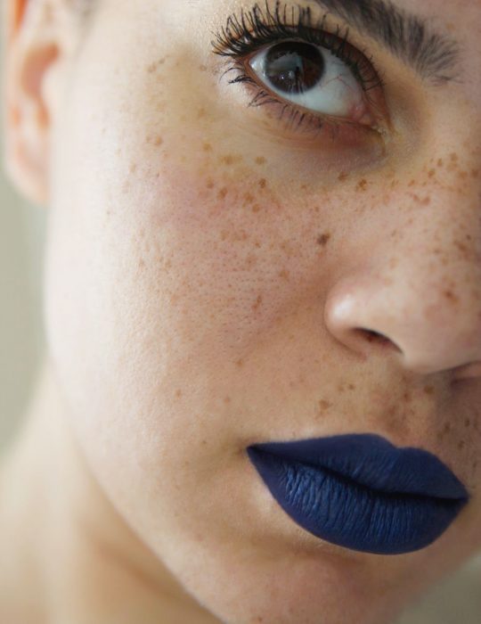 Pantone elige el classic blue como el color del 2020; mujer con pecas y labios pintados de azul clásico