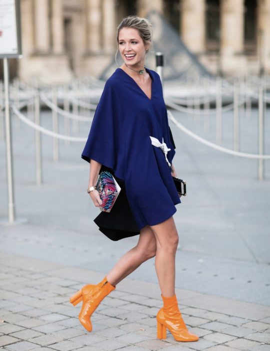 Pantone elige el classic blue como el color del 2020; mujer con vestido azul clásico con botines anaranjados