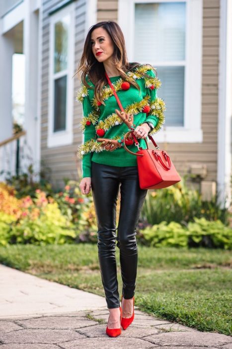 Chica usando un ugly sweter de color verde con leggins negros