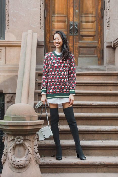 Chica usando un ugly sweter de color verde con rojo y botas grises