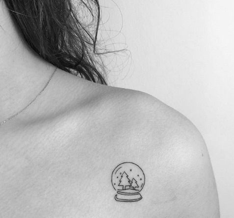 Chica mostrando su tatuaje de bola de nieve de cristal