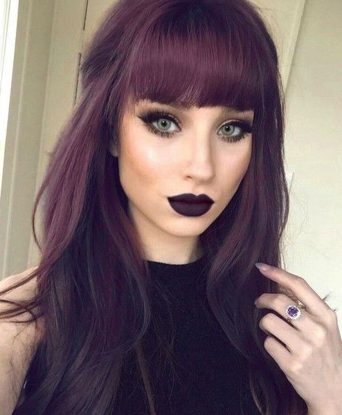 Chica mostrando su cabello de color dark violeta con flequillo y labios del mismo color