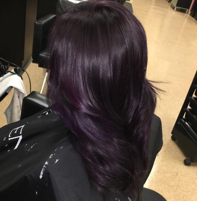 Chica mostrando su cabello de color dark violeta después de que se lo tiñeron