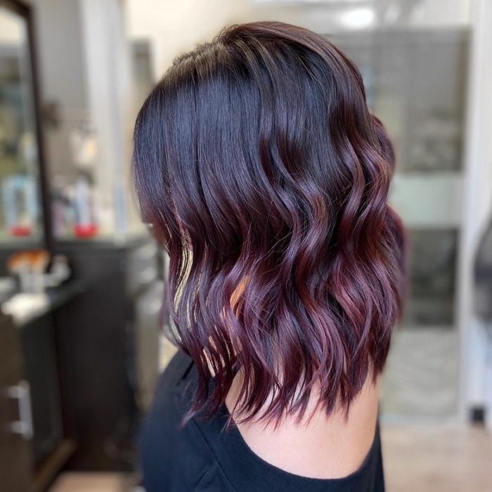 Chica mostrando su cabello de color dark violeta con pequeñas luces de colores