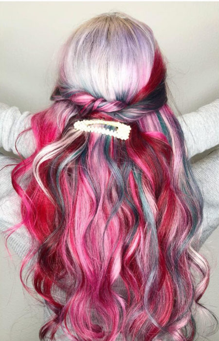 Chica con el cabello rizado y teñido de colores rojo, azul, verde y platinado