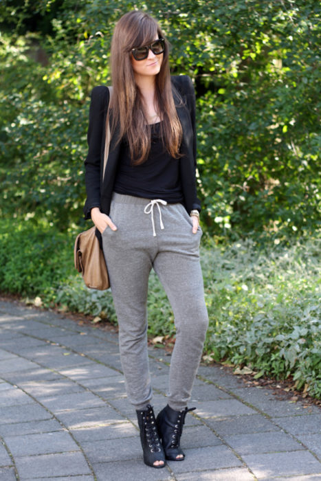 Chica usando pants grises con blusa negra y zapatos de cintas