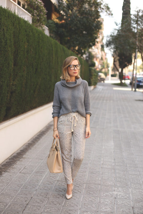 Chica usando pants beige con abrigo gris y tacones