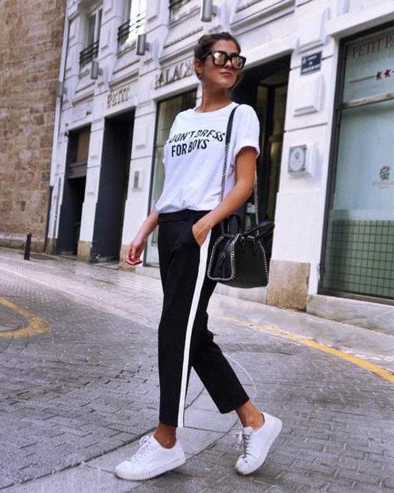 Chica con atuendo blanco y negro caminando por la calle