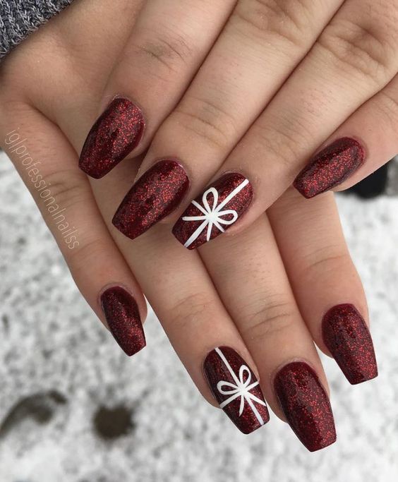 Uñas en tono vino con detalle de moño