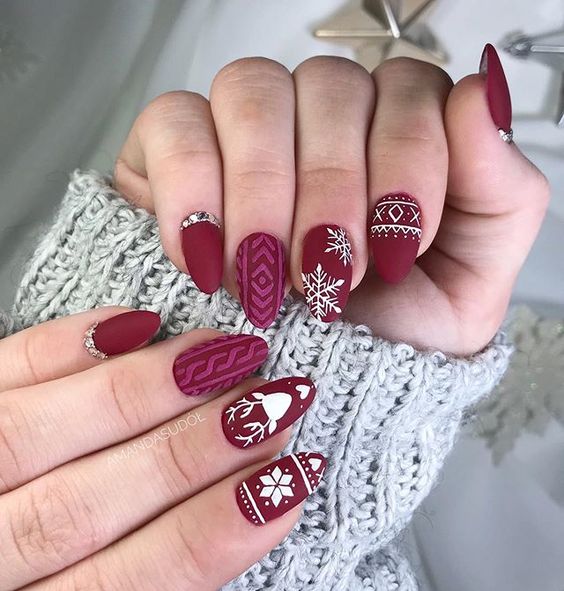 Manicura en color vino con detalles blancos de renos