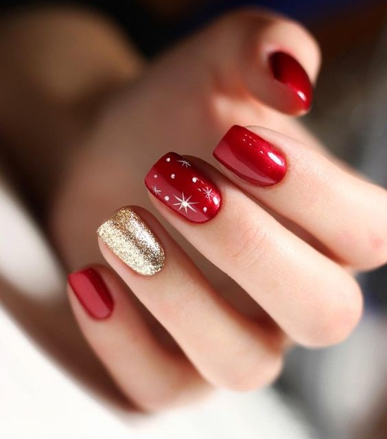 Manicura en rojo con una uña dorada