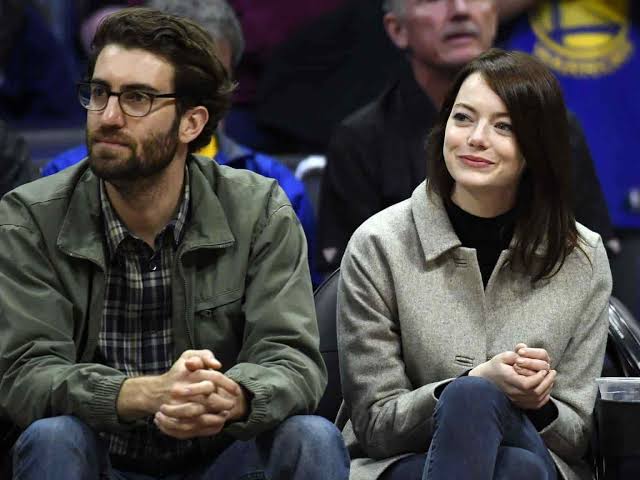 Emma Stone y Dave McCary sentados, mirando un partido de basquet
