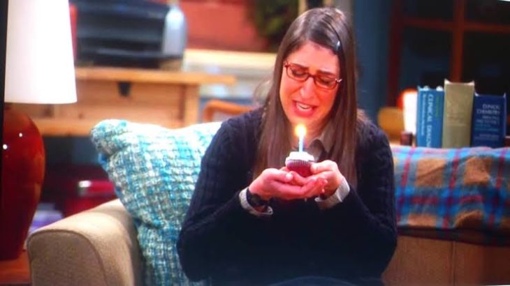Escena de The Big Bang Theory chica soplando velita cumpleaños sola