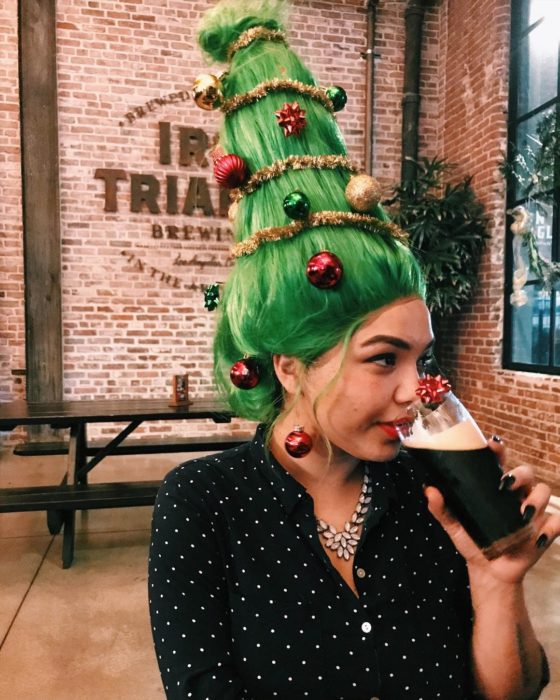 Chica con peinado alto con cabello en verde y esferas en rojo