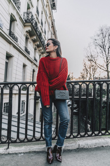 Chica usando un suéter de color rojo con jeans y botines de charol en color vino