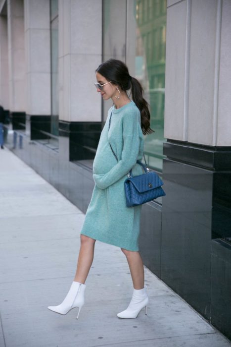 Mujer usando un vestido largo azul marino mientras posa en la calle para una sesión de fotos
