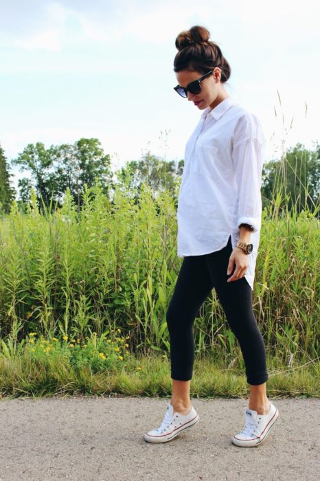 Mujer combinando leggins, camisa blanca y zapatillas Converse