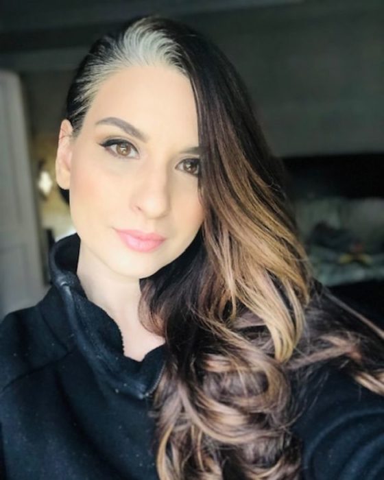 Chica con el cabello rizado mostrando sus canas en la nuca 