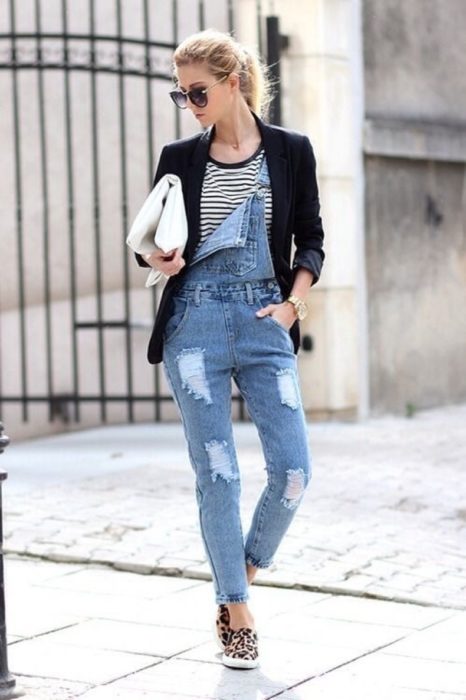 Chica usando un overol con un blazer negro, bolsa de mano y tenis de leopardo