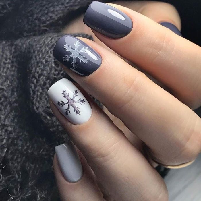 Manicura en tonos grises decorada con copos de nieve