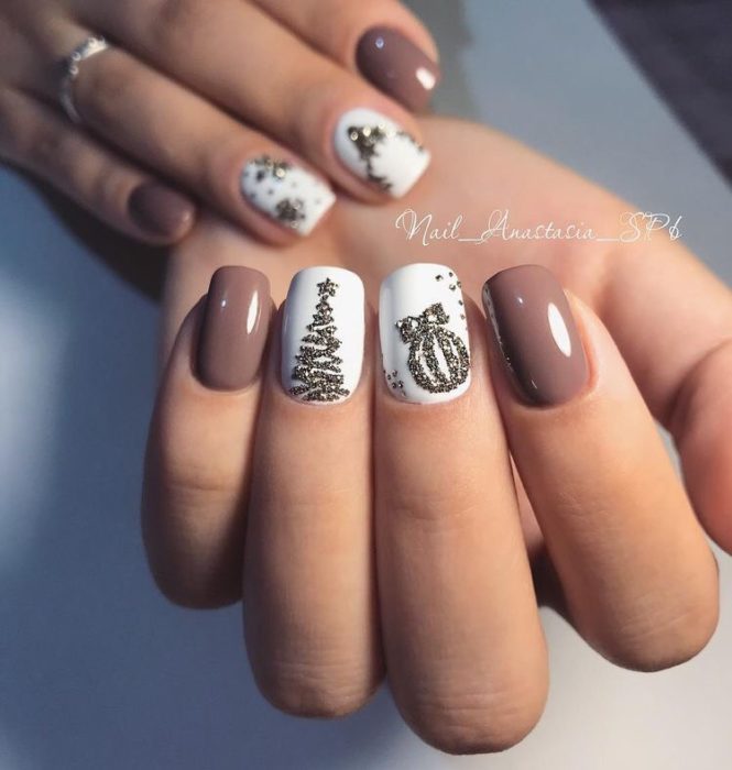 Uñas en tono malva con detalles de esferas y pinos navideños en dorado
