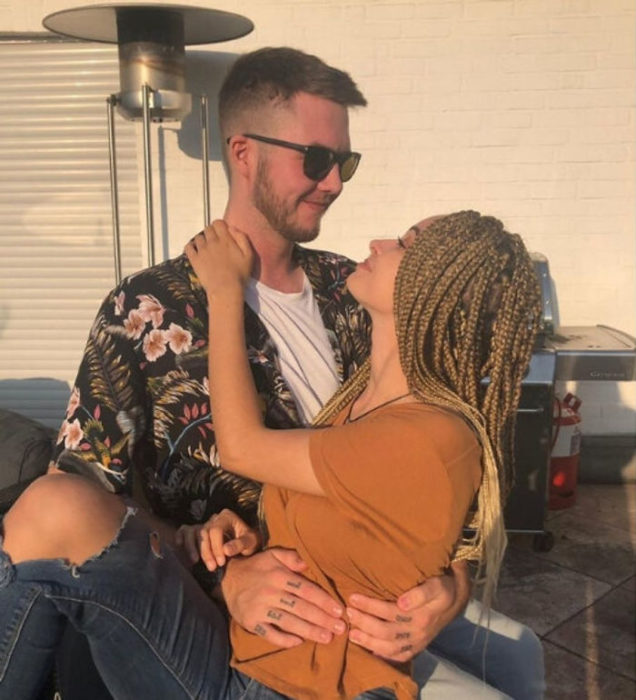 Pareja de novios abrazados y mirándose fijamente en un sofá