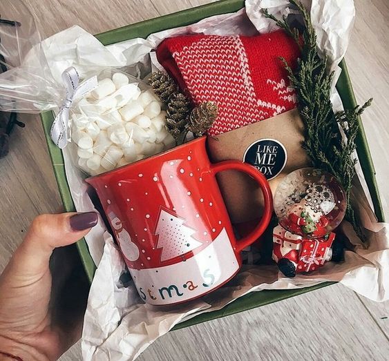 Caja de cartón rellena de bombones, una taza y una bolsa de café