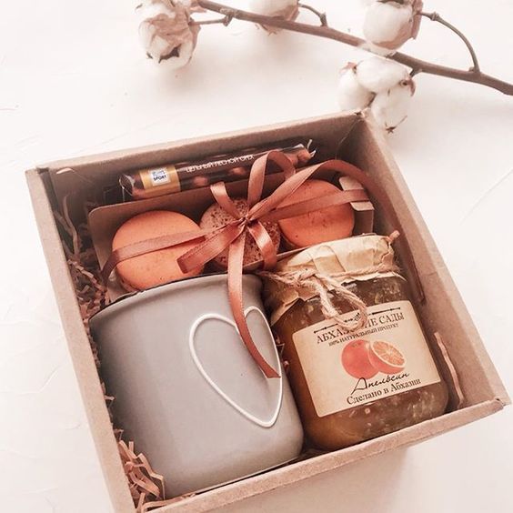 Caja de cartón con una taza y mermelada de naranja