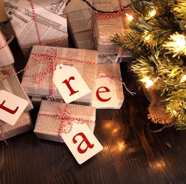 Regalos decorados con papel periódico y listones en rojo