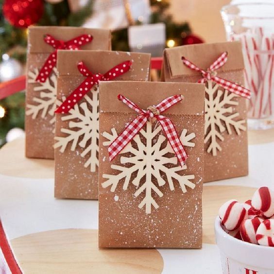 Bolsas de papel decoradas con copos de nieve de papel reciclado