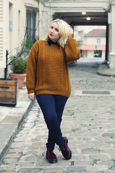 Chica plus size con suéter amarillo, jeans oscuros y botas negras dr. martens