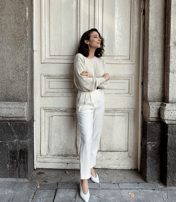 chica de cabello corto con pantalón blanco, suéter blanco y zapatillas blancas