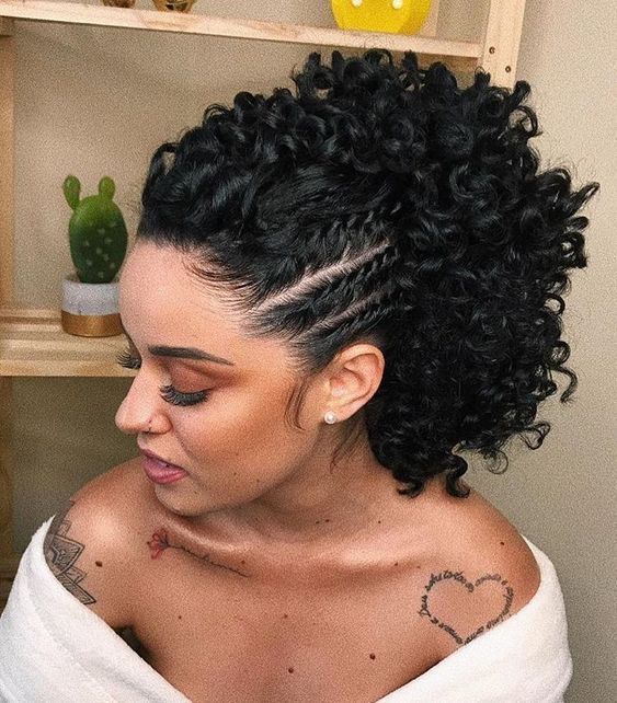 Mujer de cabello negro rizado con recogido alto con torciditos