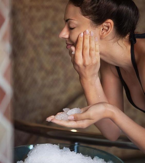 Chica poniendo hielo sobre su rostro para evitar envejecimiento prematuro