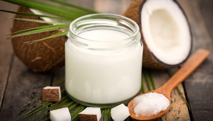 Recipiente con aceite de coco orgánico y cuchara de bambú