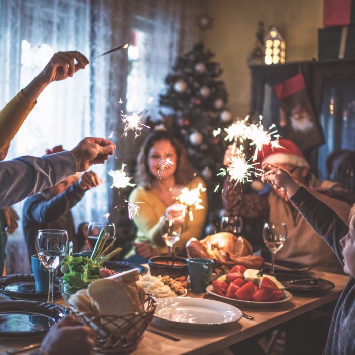 Familia reunida en cena de Navidad, con luces de bengala