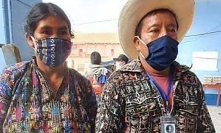 Pareja de abuelitos agricultores cubriendo su rostro con un cubrebocas