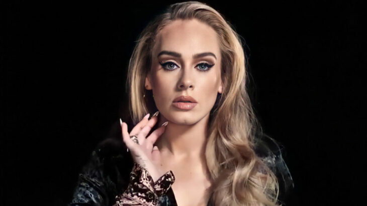 Adele posa con elegancia mirando fijamente a la cámara, lleva las uñas largas y pintadas y el cabello suelto
