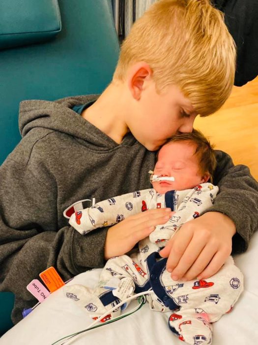 Rayce besando a su hermanito Tripp en el hospital