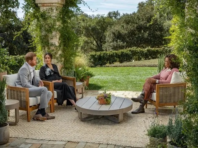 Harry y Meghan sentados en un sofá durante la entrevista con Oprah en su jardín