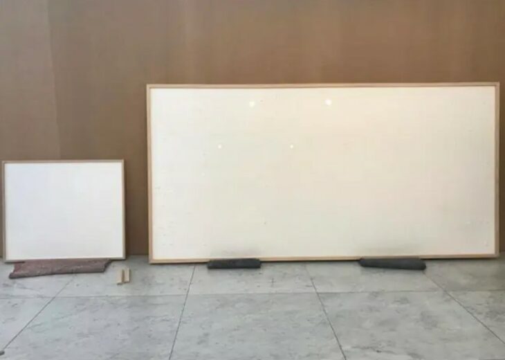 Artista mostrando su obra de dos lienzos vacíos