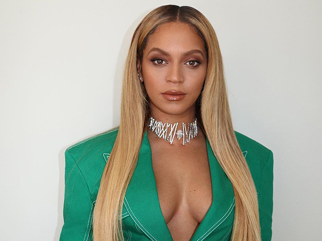 Cantante Beyoncé vestida con chaqueta verde esmeralda y collar de brillantes